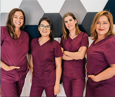 Four smiling dental team members at Fisher Dental